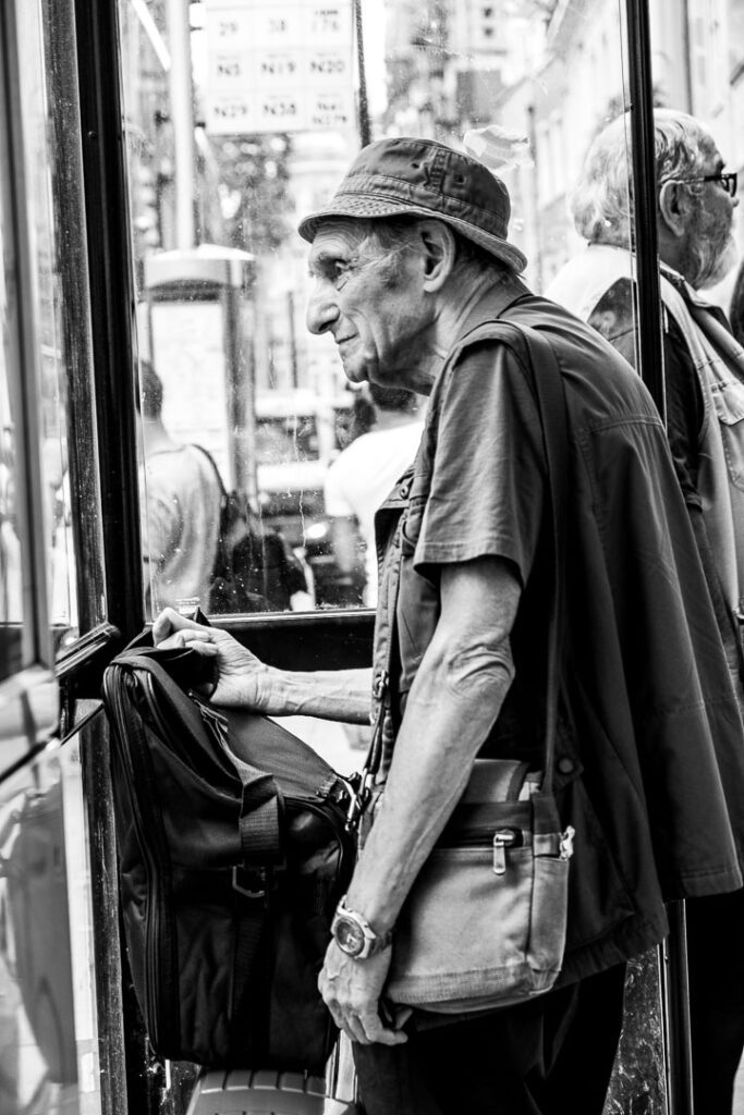 London street photography - old man at bus stop by Adrian Crook