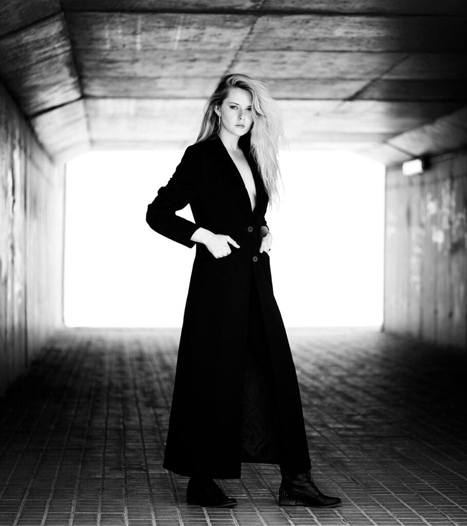 Fashion photography. Model in black coat in a underpass in Spain