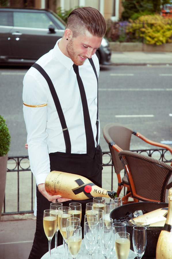 Adrian Crook Social Media image of Barman pouring champagne