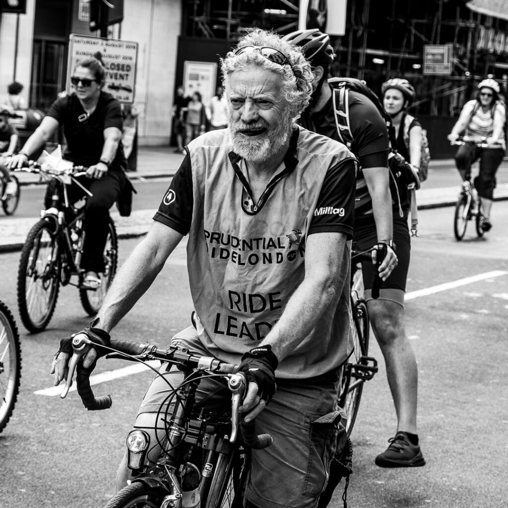 London street photography - Man cycling in London by Adrian Crook